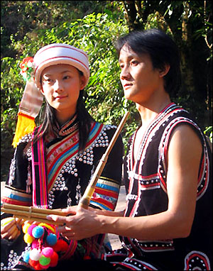 A photo of a fresh married couple, wearing traditional clothes with the predominany color being black with white trim.