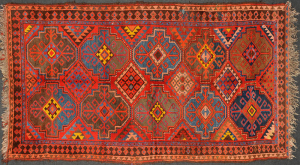Antique Uzbek Rug, having a red color pallete with geometrical forms in the middle of various colors, surrounded by a black and red checkered border.